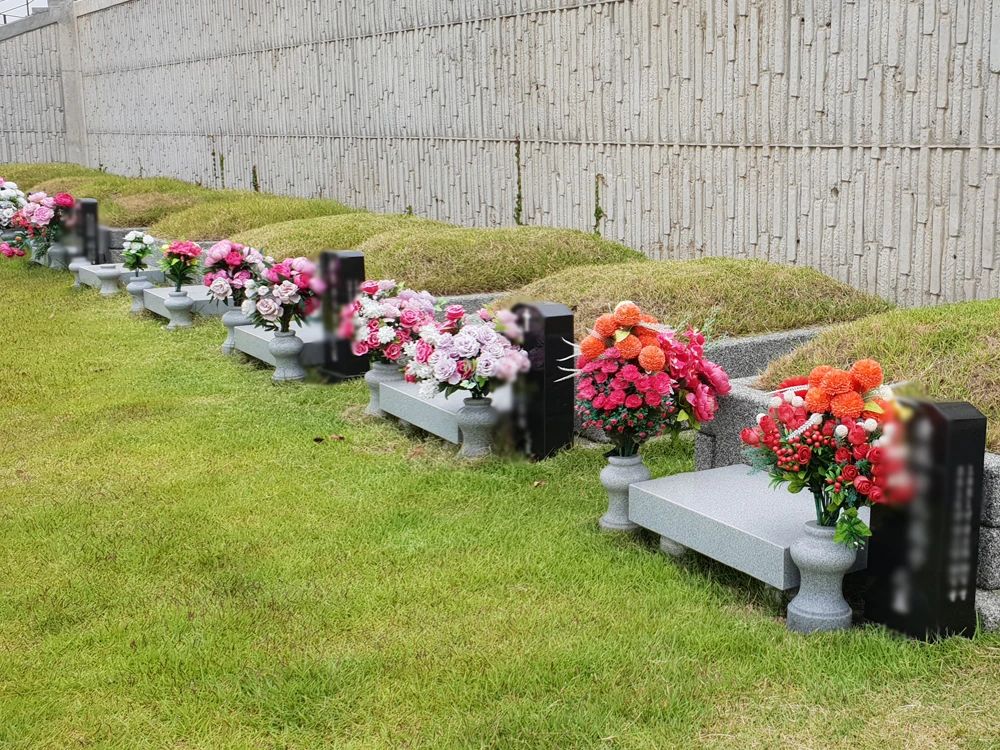 일산추모공원 꽃이 헌화된 계단식 봉분 매장묘역